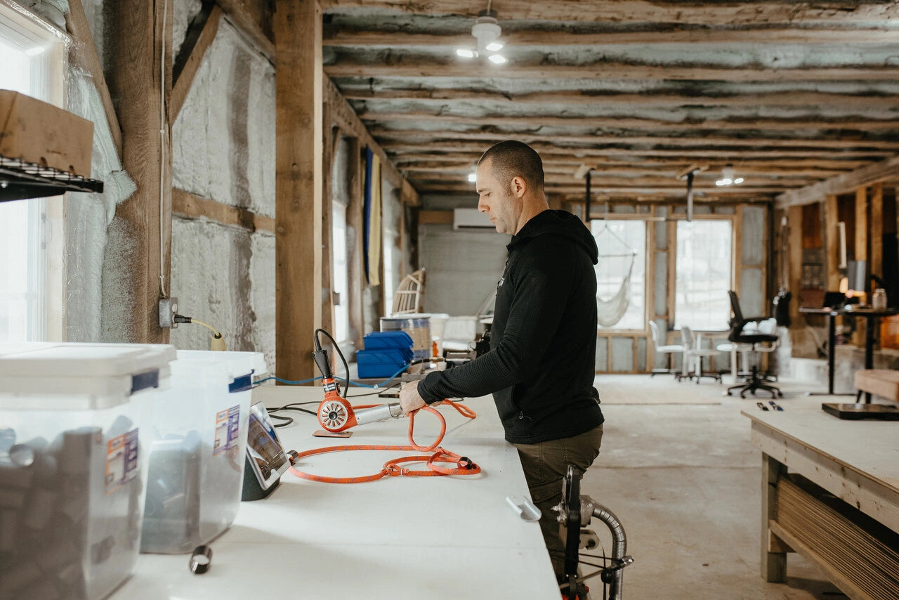 Close-up of black leash being hand-crafted on a wooden jig, showing durable woven materials and handmade construction process.