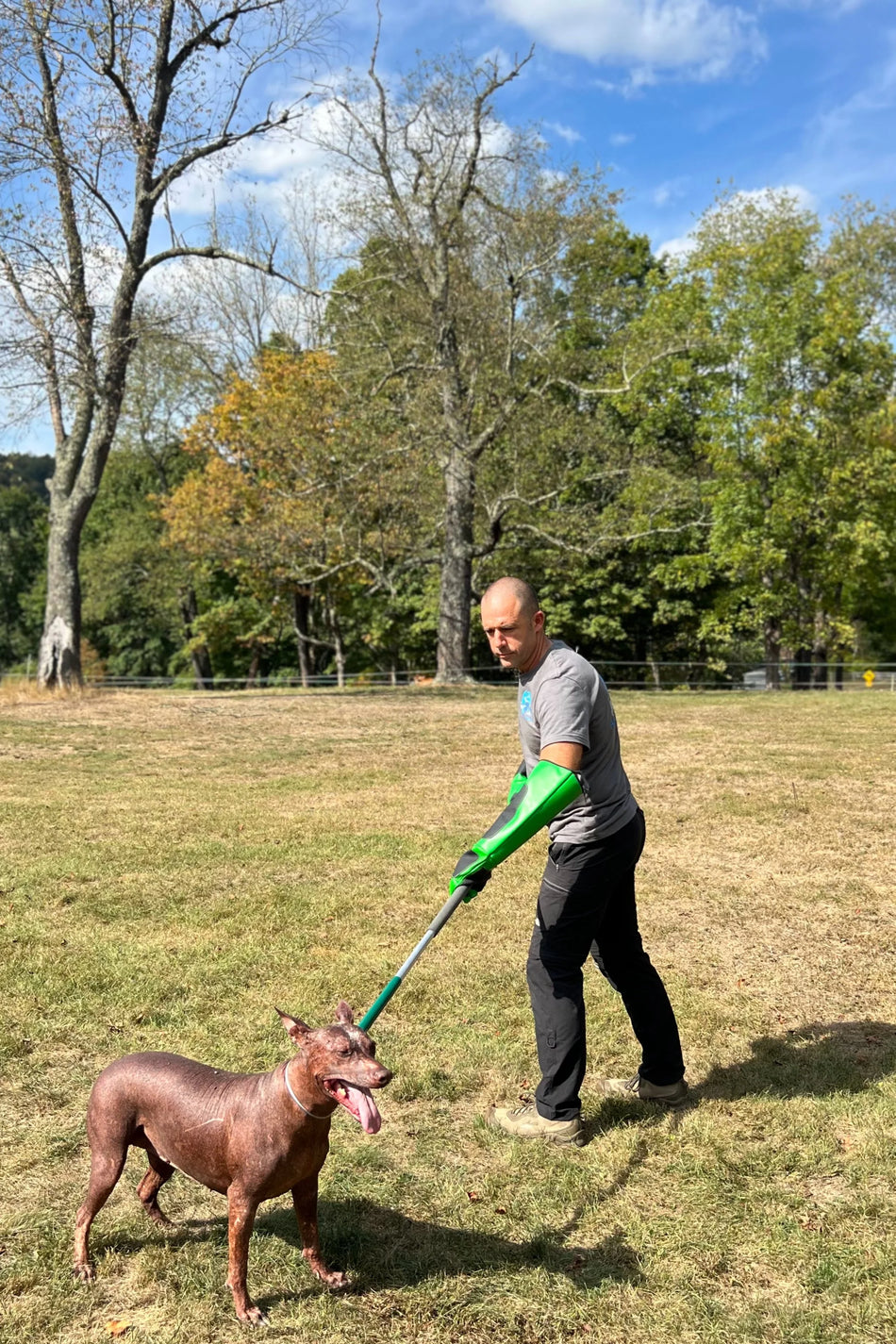 Dog in outdoor setting wearing tan Humane Innovations muzzle, shown from side profile to highlight secure, mesh-based fit.